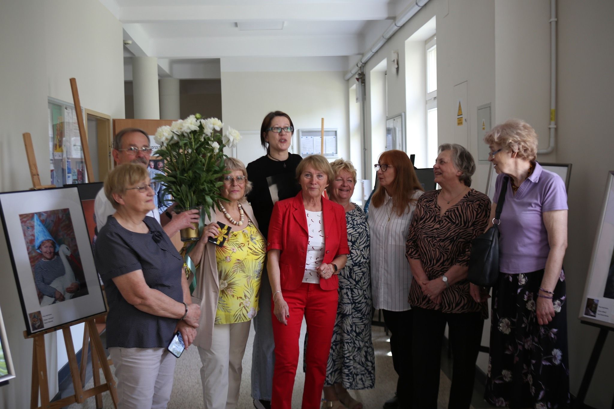 Grupa ludzi otaczająca się pracami