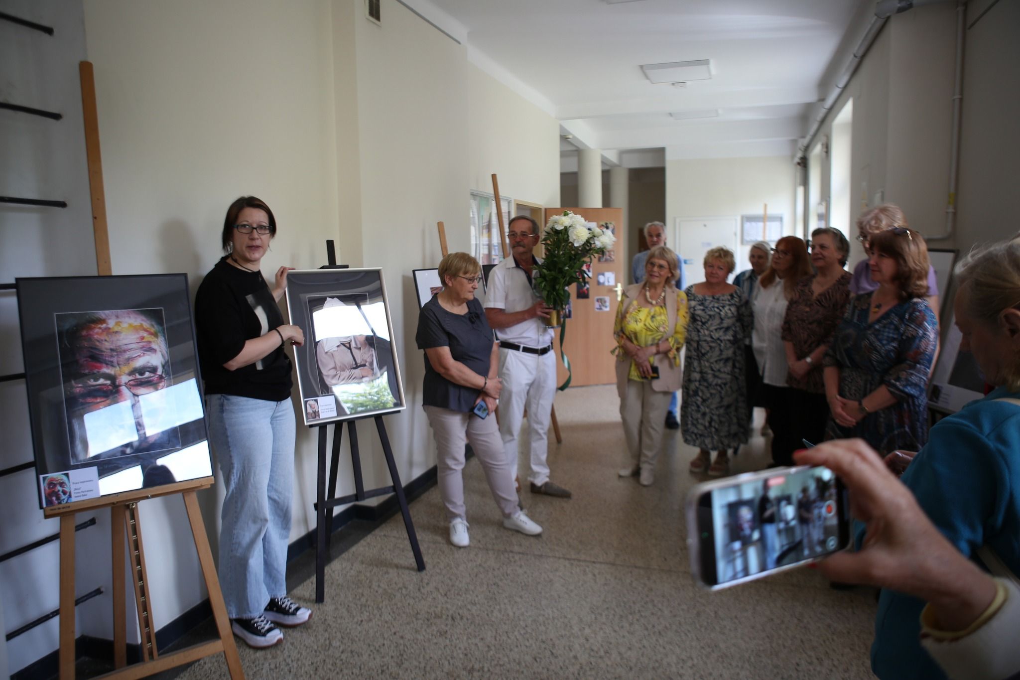 Grupa ludzi otaczająca się pracami